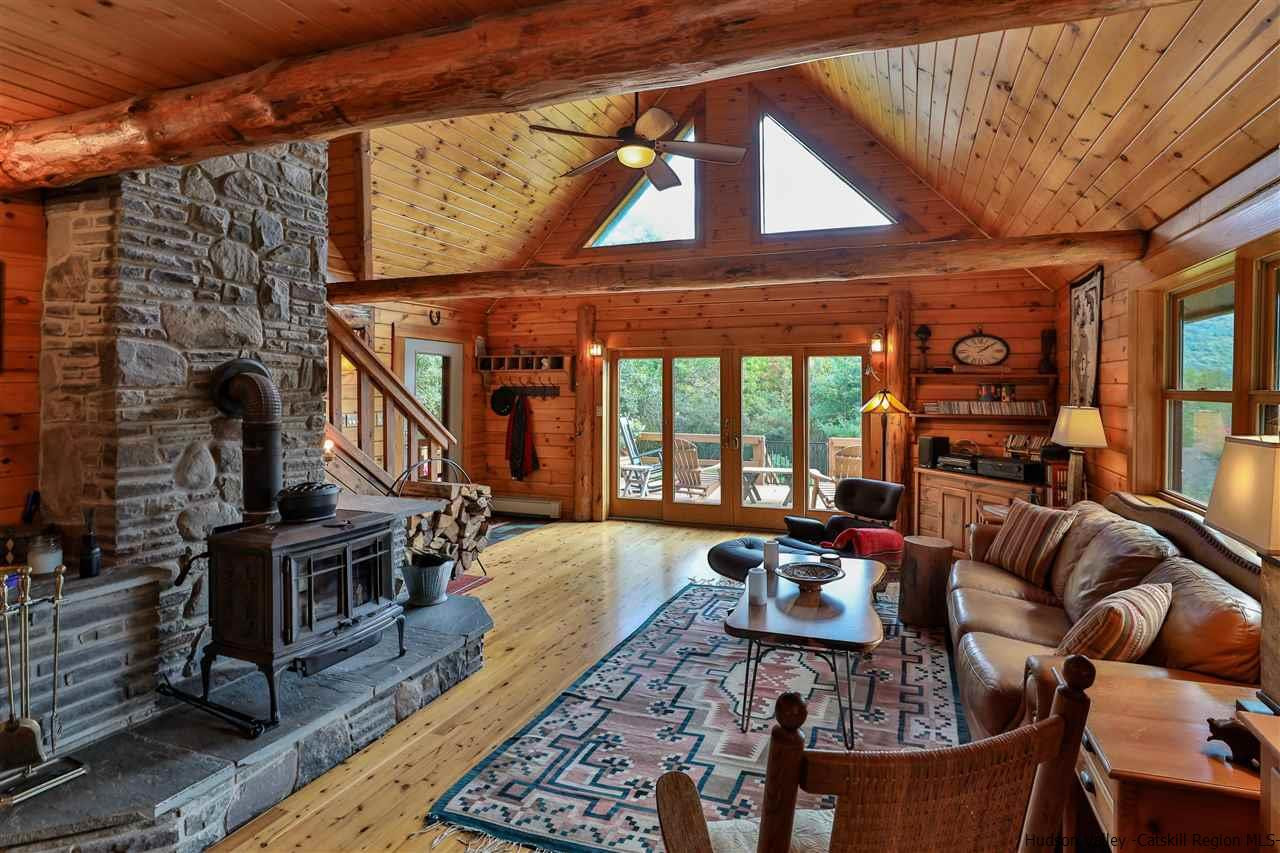 391 Tumbleweed Ranch Road West Kill, NY 12492 - Photo 8 of 35 a living room with furniture a flat screen tv and a floor to ceiling window