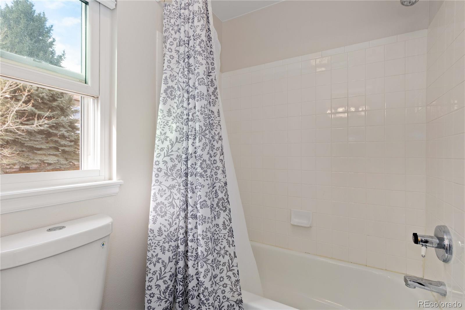 758 Huntington Place Highlands Ranch, CO 80126 - Photo 28 of 46 a bathroom with a shower curtain and a window