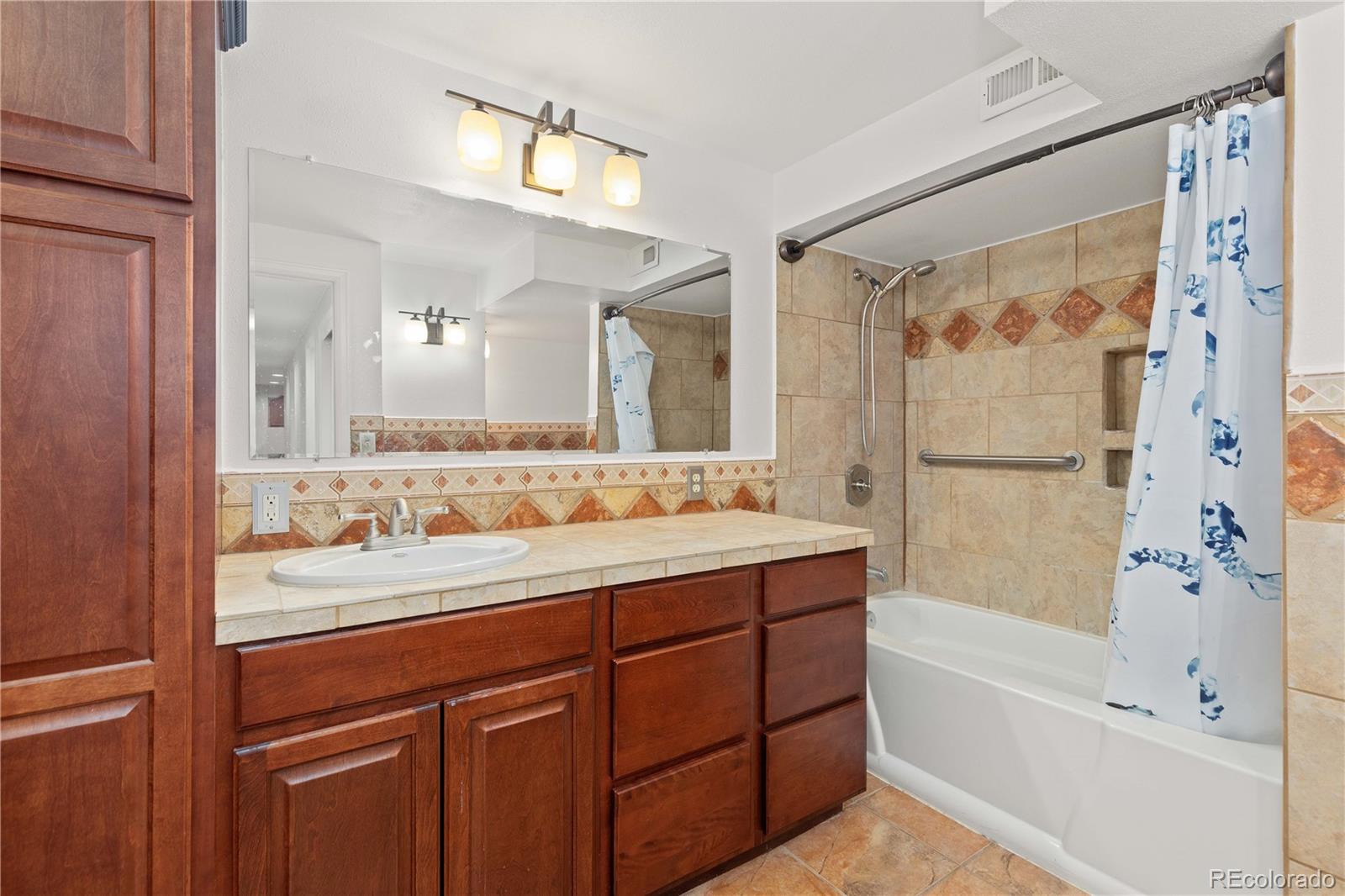 758 Huntington Place Highlands Ranch, CO 80126 - Photo 37 of 46 a bathroom with a bathtub shower sink and mirror