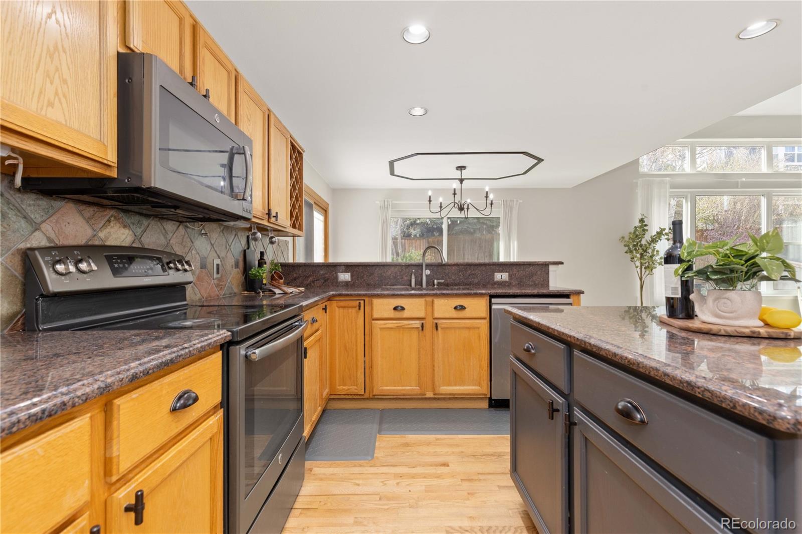 758 Huntington Place Highlands Ranch, CO 80126 - Photo 7 of 46 a kitchen with stainless steel appliances granite countertop a sink a stove and a wooden cabinets