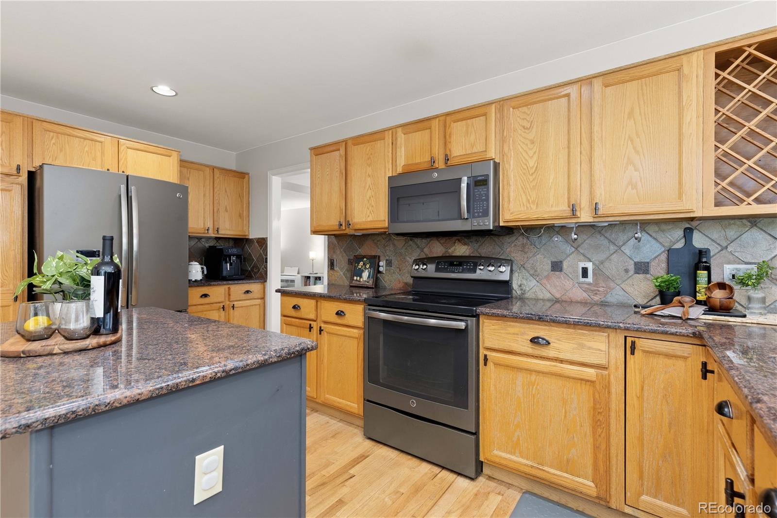 758 Huntington Place Highlands Ranch, CO 80126 - Photo 9 of 46 a kitchen with stainless steel appliances granite countertop a stove a sink and a microwave
