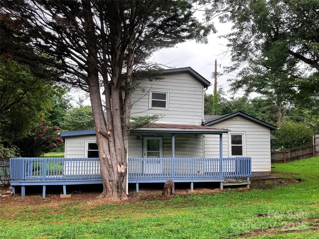 a front view of a house with a garden and deck