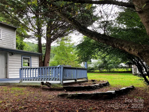a view of a backyard with wooden floor and fence