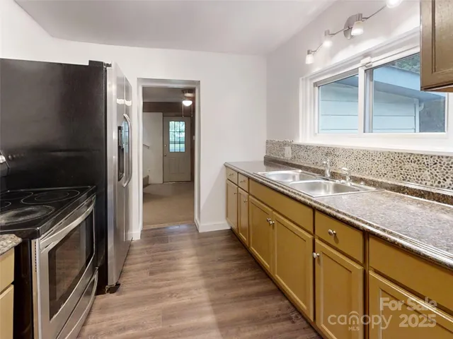 a kitchen with granite countertop a sink and a stove top oven