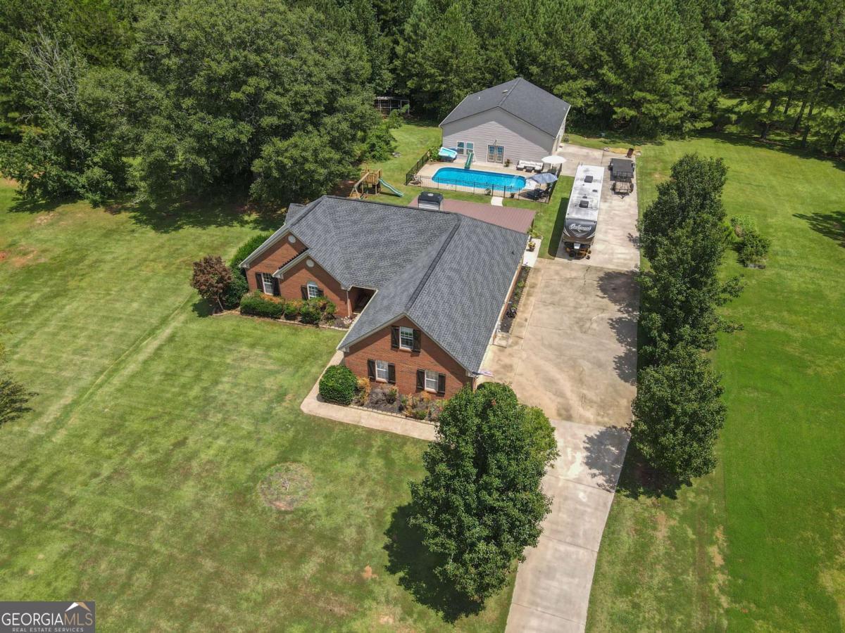 an aerial view of a house with swimming pool and garden