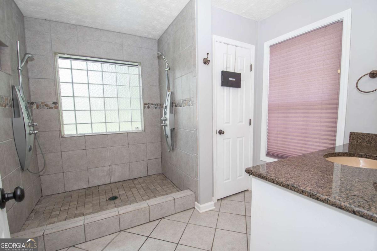 737 John Lovelace Road LaGrange, GA 30241 - Photo 15 of 46 a bathroom with a granite countertop sink a shower and a mirror
