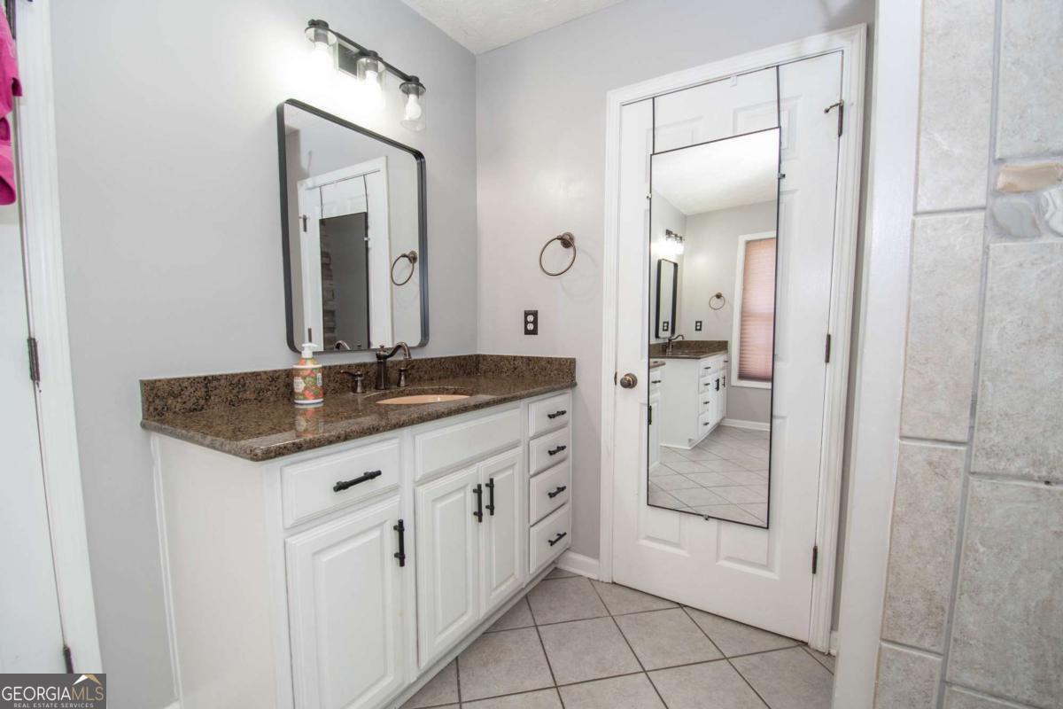 737 John Lovelace Road LaGrange, GA 30241 - Photo 16 of 46 a bathroom with a granite countertop sink two mirror and a mirror
