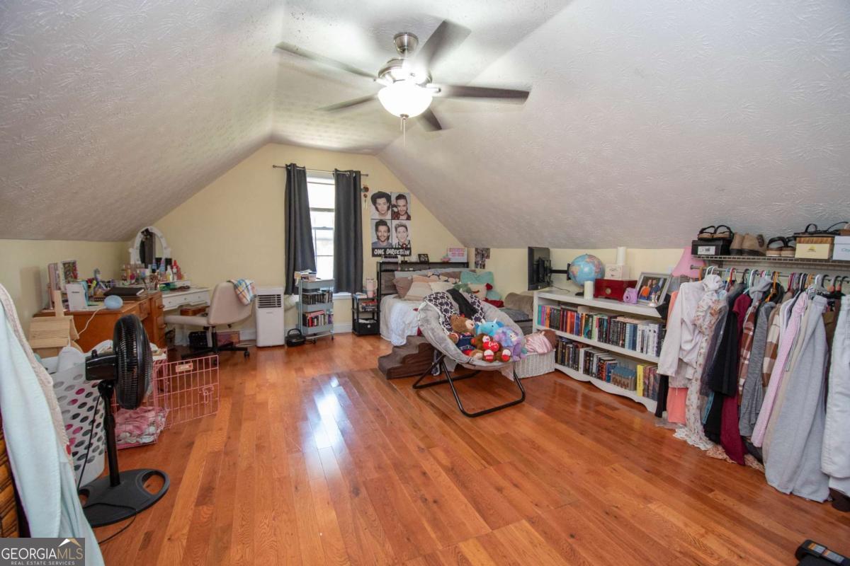 737 John Lovelace Road LaGrange, GA 30241 - Photo 24 of 46 a living room with lots of furniture and a book shelf