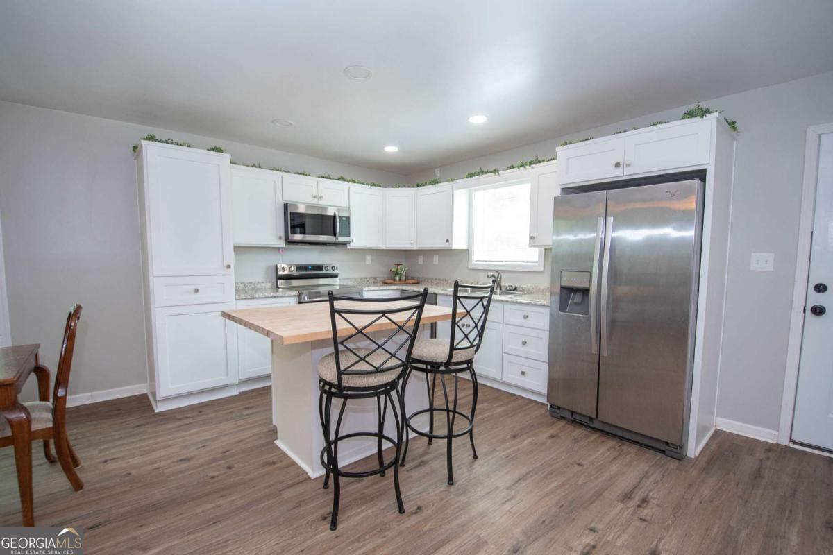 737 John Lovelace Road LaGrange, GA 30241 - Photo 40 of 46 a kitchen with stainless steel appliances a refrigerator a stove a sink dishwasher and a refrigerator with wooden floor