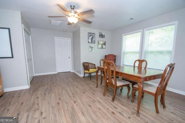 a view of a dining room with furniture a chandelier and wooden floor