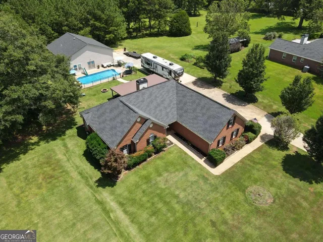 an aerial view of a house with yard swimming pool and outdoor seating