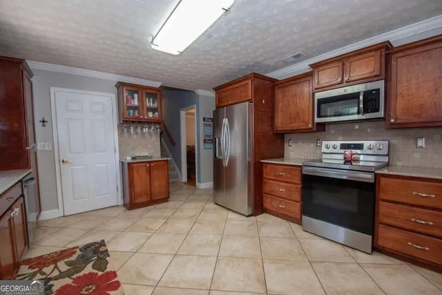 a kitchen with stainless steel appliances granite countertop a refrigerator and a stove top oven