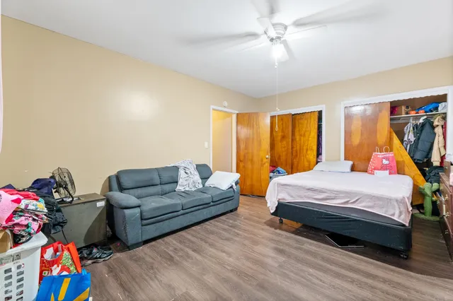 a bedroom with a bed and wooden floor