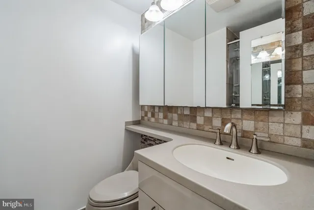 a bathroom with a sink a toilet and mirror