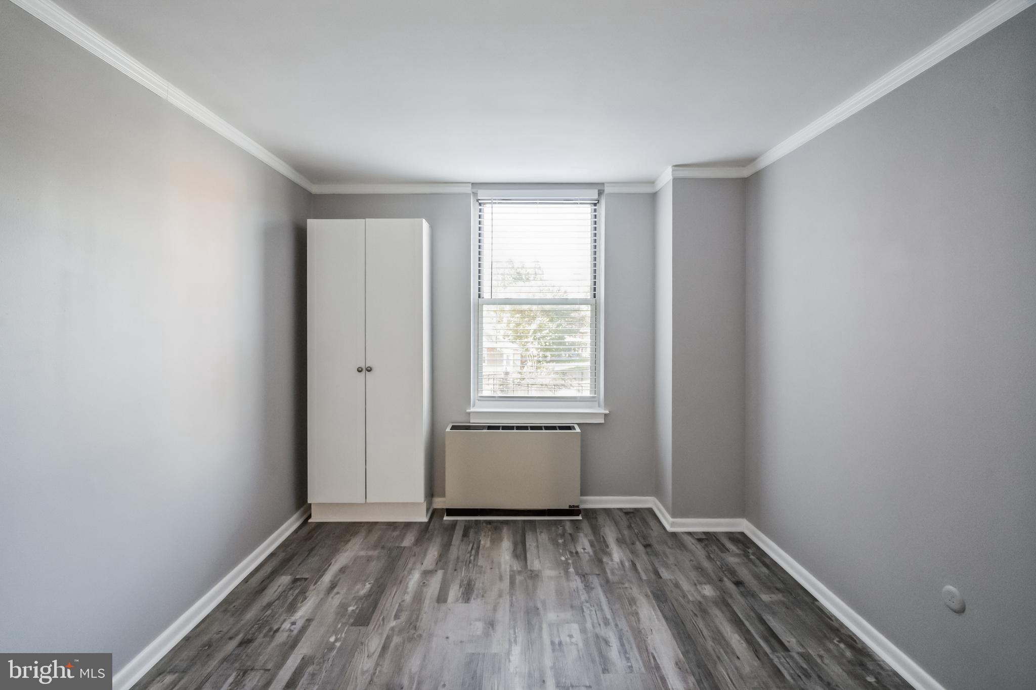 6100 Henry Avenue, Unit 4I Philadelphia, PA 19128 - Photo 21 of 30 a view of an empty room with wooden floor and a window