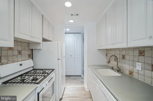 a kitchen with granite countertop a sink stove and cabinets