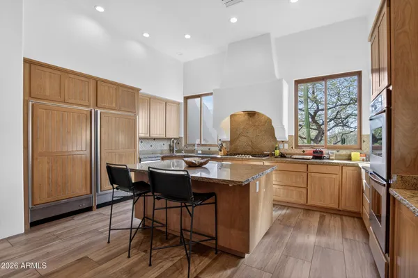 a kitchen with a sink and a stove top oven with wooden floor