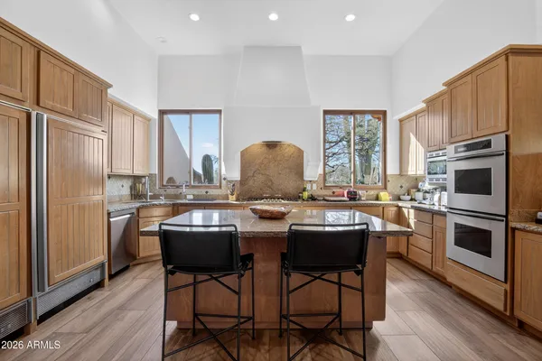 a living room with stainless steel appliances kitchen island granite countertop a sink and cabinets
