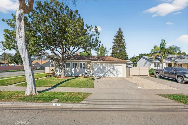 a front view of a house with a yard and trees