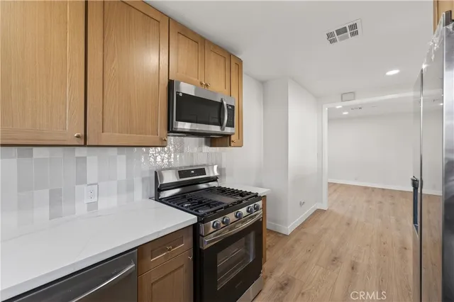 a view of a big room with wooden floor and windows