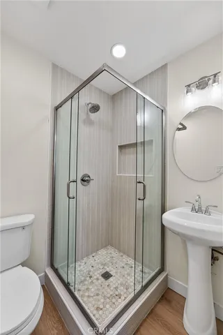 a bathroom with a sink a toilet and shower