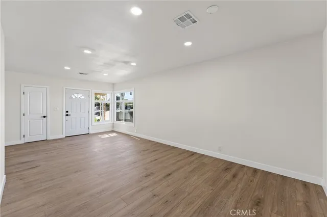 a view of an empty room with wooden floor
