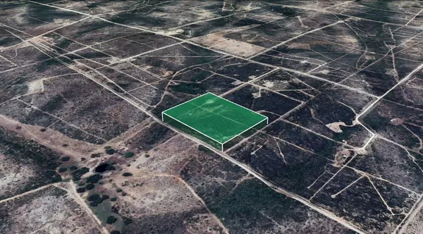 a green field with lots of trees in the background