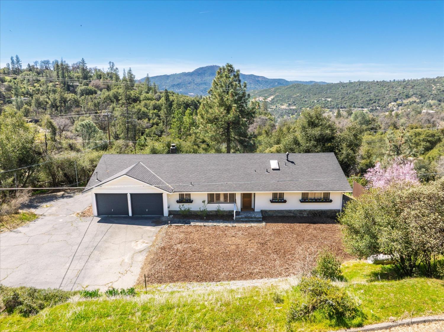 a aerial view of a house with a yard and trees in the background