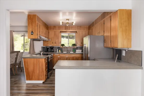 a kitchen with stainless steel appliances granite countertop a refrigerator a stove and a sink