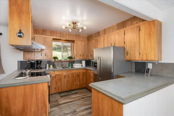 a kitchen with stainless steel appliances granite countertop a sink refrigerator stove and microwave