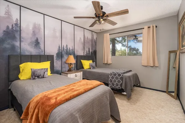 a bedroom with two beds and a chandelier