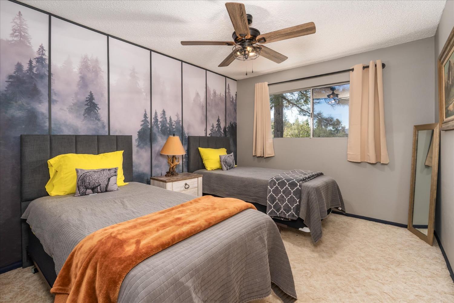 42324 Buckeye Road Oakhurst, CA 93644 - Photo 23 of 45 a bedroom with two beds and a chandelier