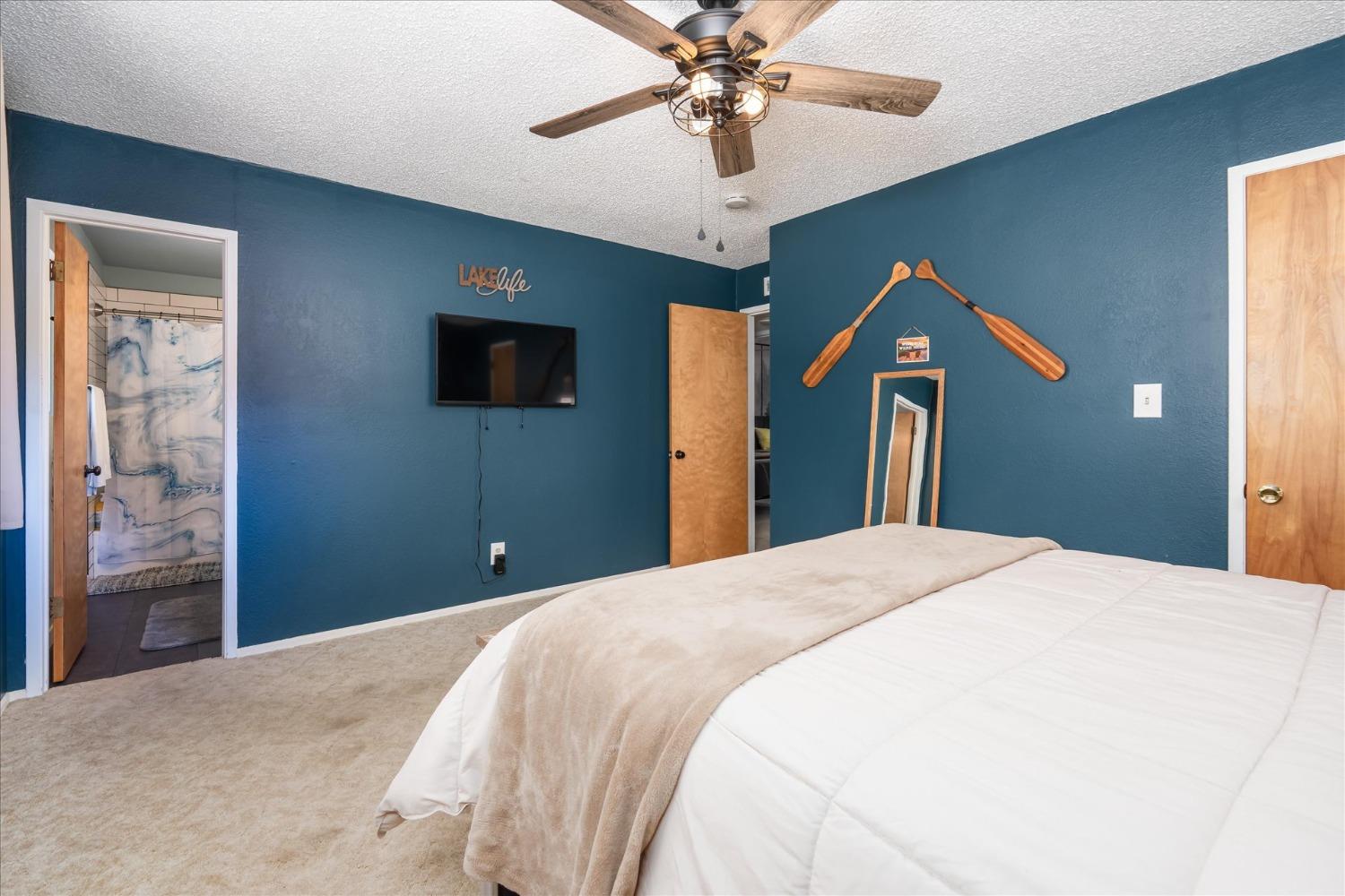 42324 Buckeye Road Oakhurst, CA 93644 - Photo 25 of 45 a bedroom with a bed and a chandelier