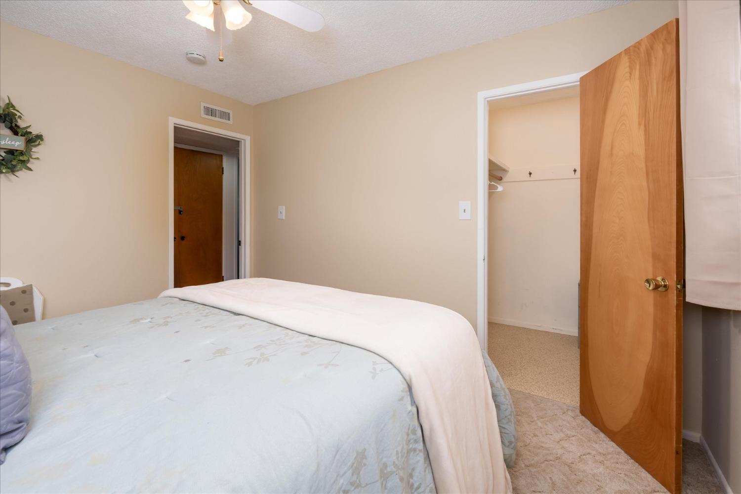42324 Buckeye Road Oakhurst, CA 93644 - Photo 29 of 45 a bedroom with a bed and a chandelier