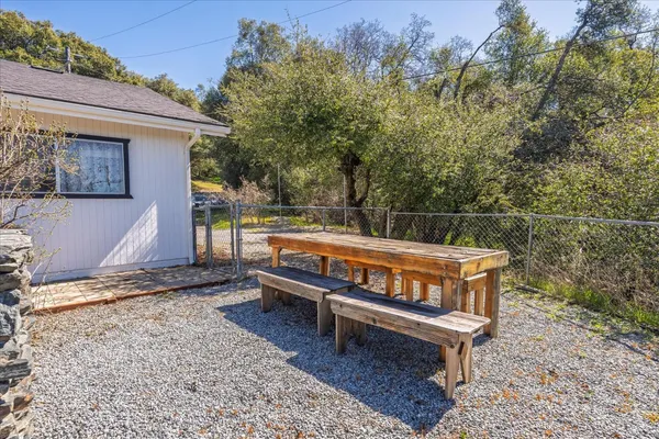 a view of a wooden chairs and bench in the backyard