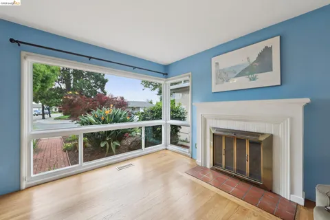 wooden floor fireplace and windows in an empty room