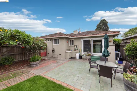 a view of a house with backyard sitting area and garden