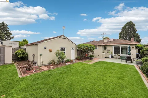 a view of a house with a yard and sitting area