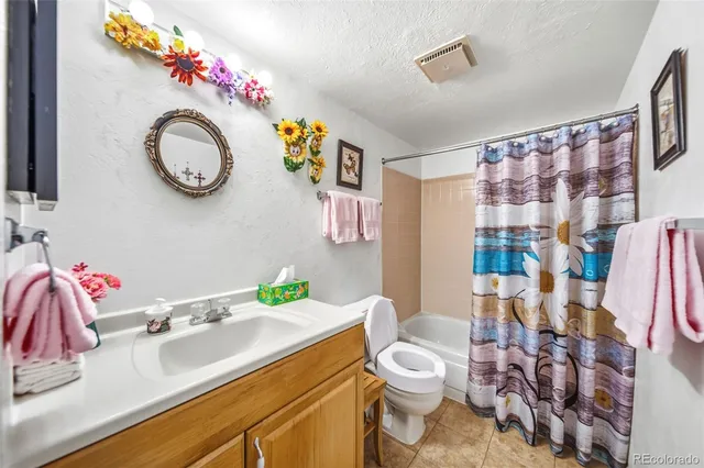 a bathroom with a sink mirror vanity and toilet