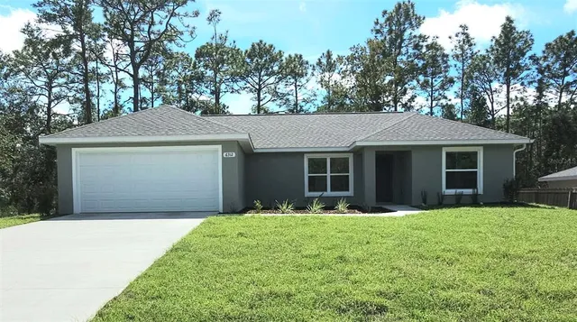 a front view of a house with a yard and trees