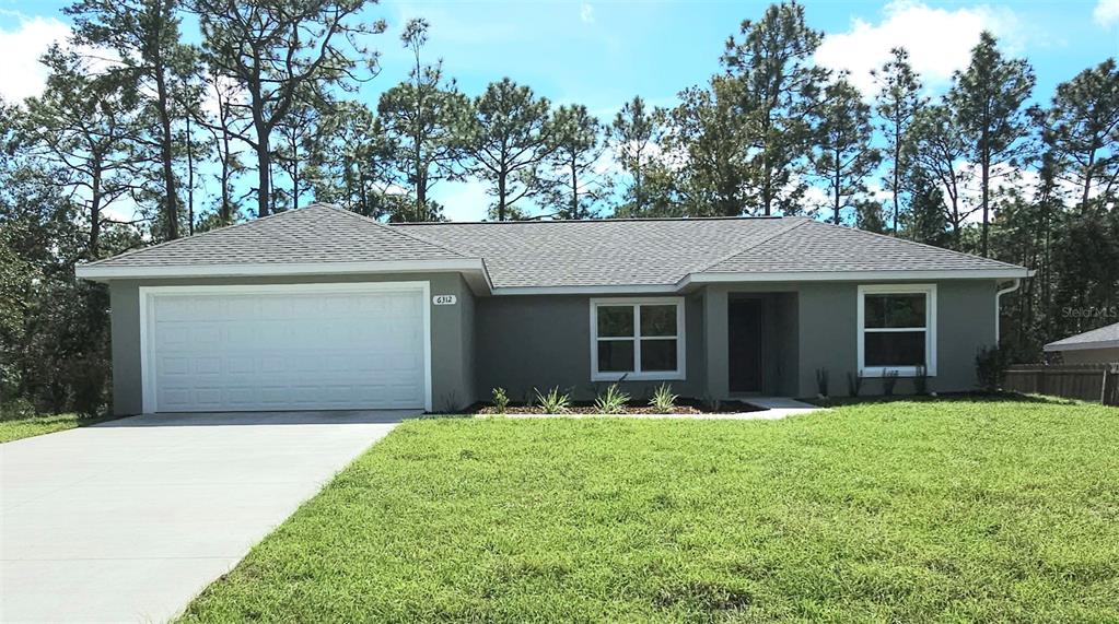 6312 Southwest 134th Loop Ocala, FL 34473 - Photo 1 of 13 a front view of a house with a yard and trees
