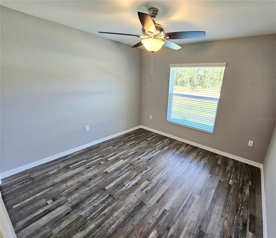 6312 Southwest 134th Loop Ocala, FL 34473 - Photo 11 of 13 wooden floor in an empty room with a window