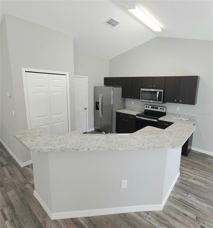 6312 Southwest 134th Loop Ocala, FL 34473 - Photo 2 of 13 a kitchen with stainless steel appliances kitchen island a stove a sink and a refrigerator