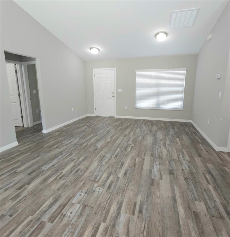 6312 Southwest 134th Loop Ocala, FL 34473 - Photo 4 of 13 an empty room with wooden floor and windows