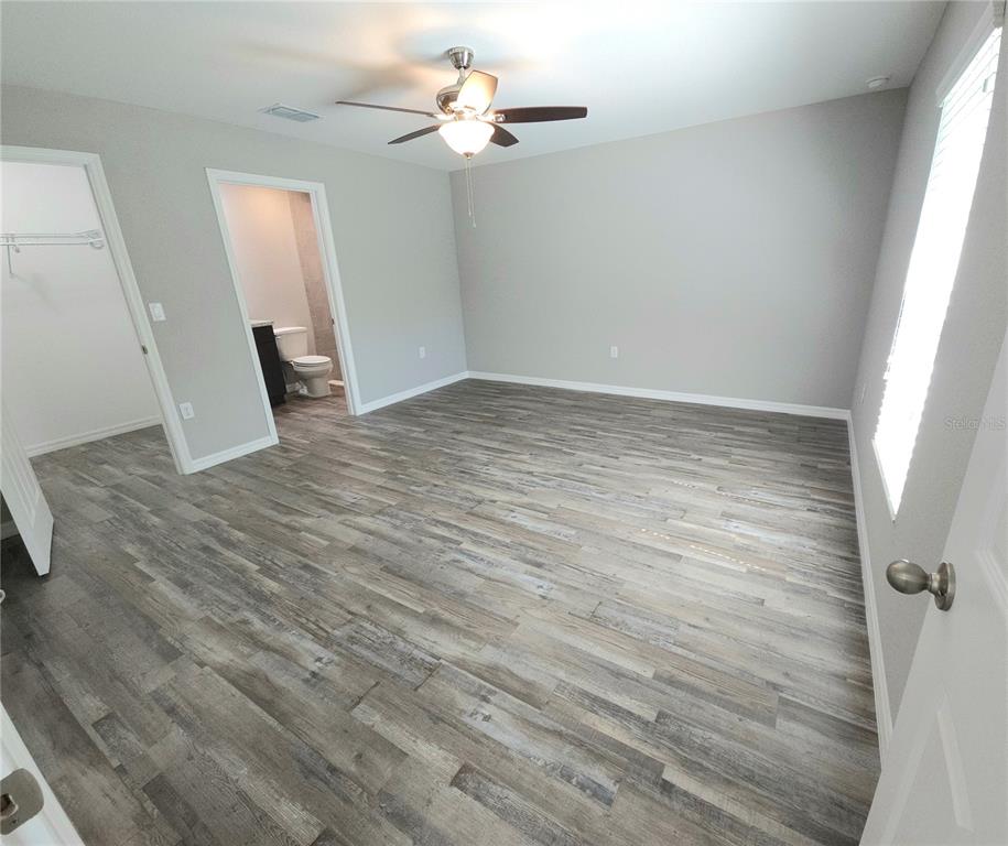 6312 Southwest 134th Loop Ocala, FL 34473 - Photo 8 of 13 wooden floor in an empty room with a window