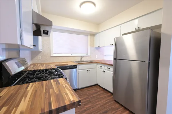 a kitchen with a refrigerator and a stove top oven