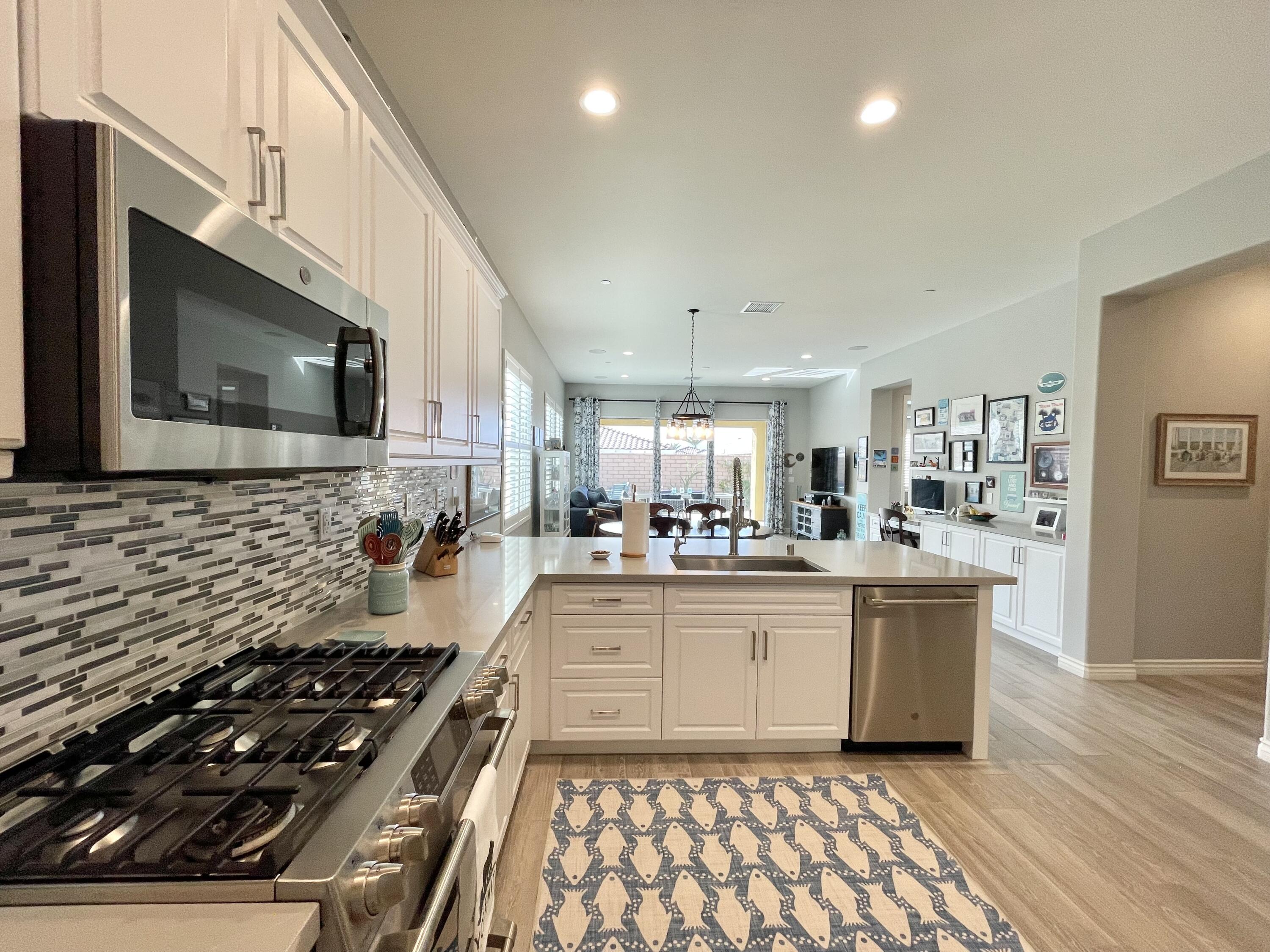 43573 Adria Drive Indio, CA 92203 - Photo 13 of 63 a kitchen with stainless steel appliances a stove a sink and a microwave