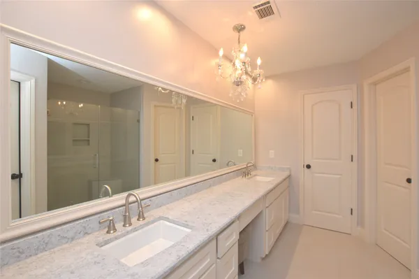 a spacious bathroom with a granite countertop sink a mirror and a shower