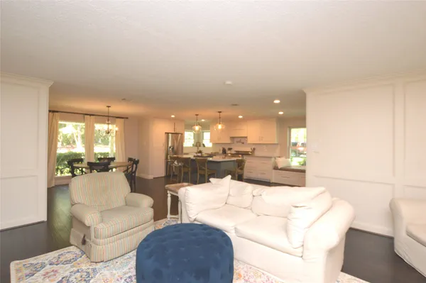 a living room with furniture white walls and a view of kitchen