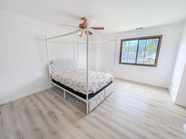 a living room with hard wood floors and a ceiling fan